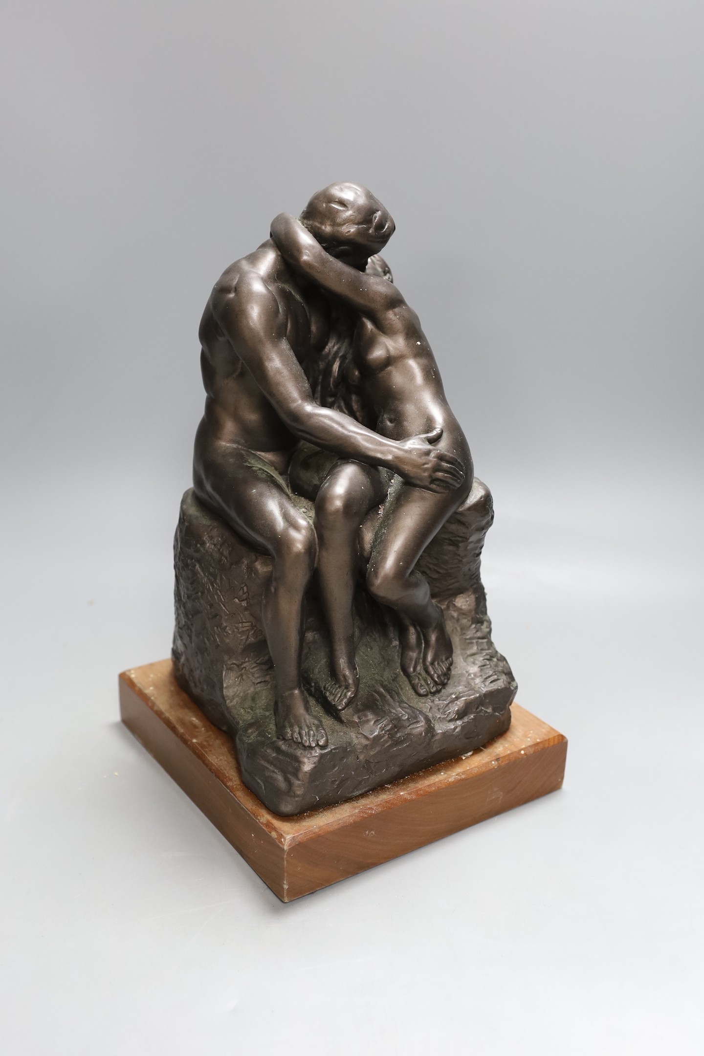 A simulated bronze figure group of seated embracing couple - 30cm tall